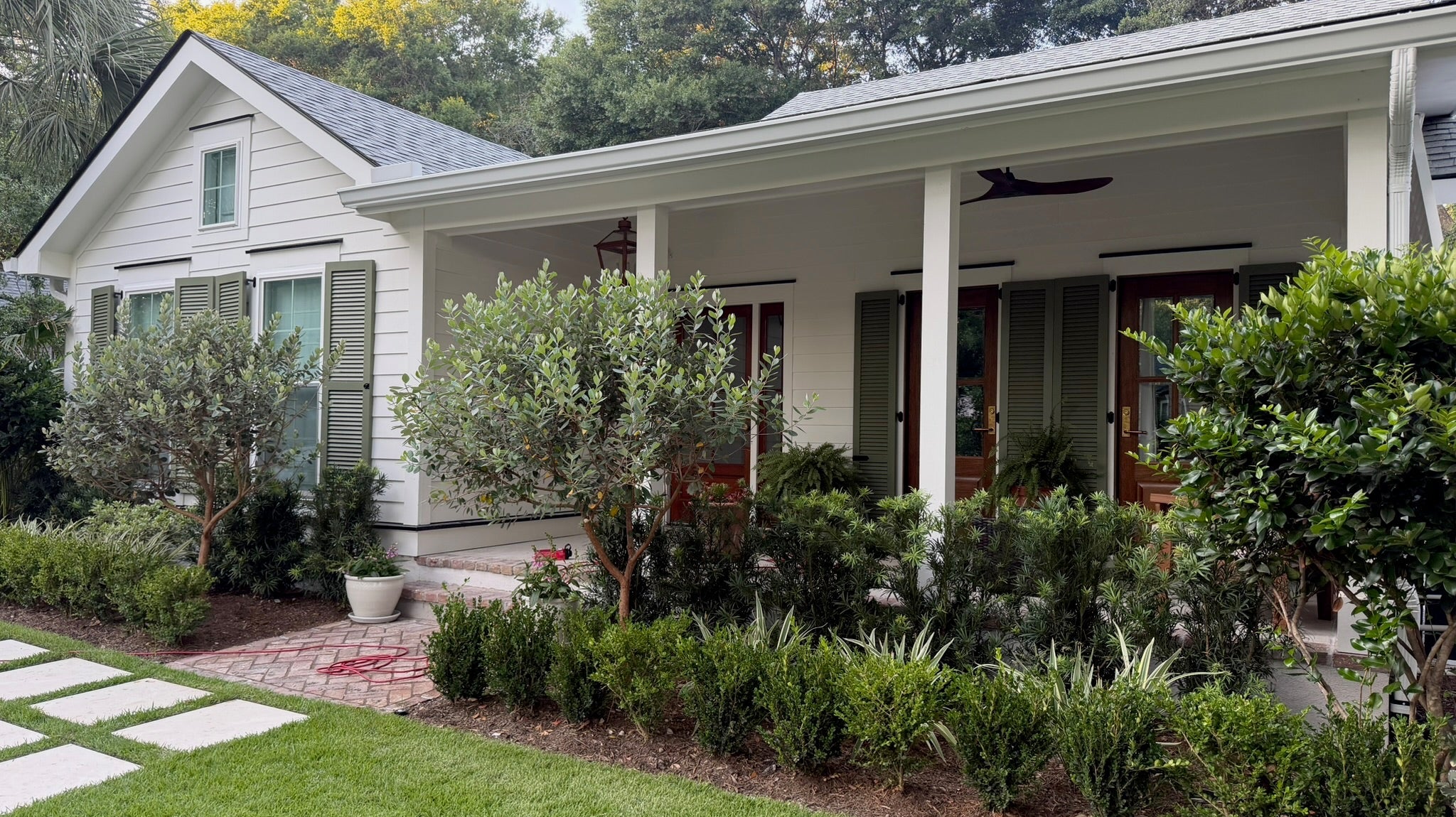 White Charleston home with Benjamin Moore Simply White exterior paint and Great Barrington Green shutters