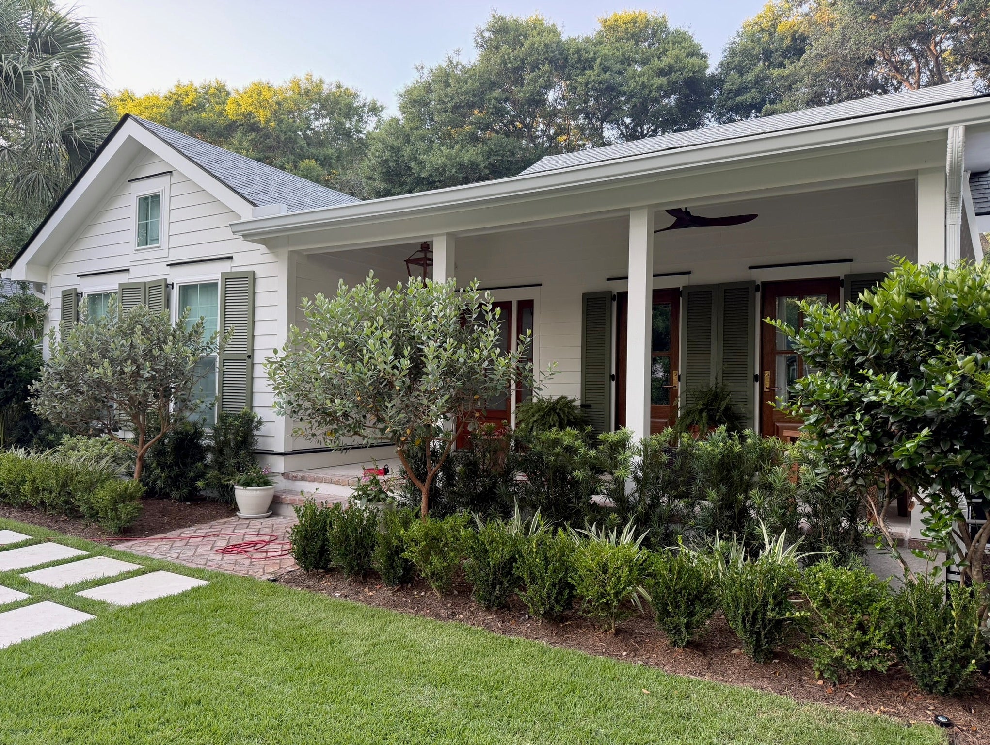 White Charleston home with Benjamin Moore Simply White exterior paint and Great Barrington Green shutters