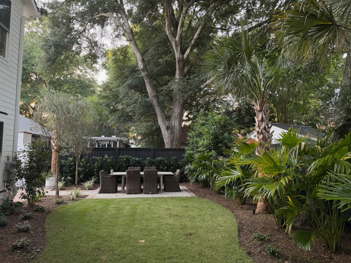 Small Charleston backyard with layered landscaping, garden pathways, privacy planting, and functional outdoor living spaces