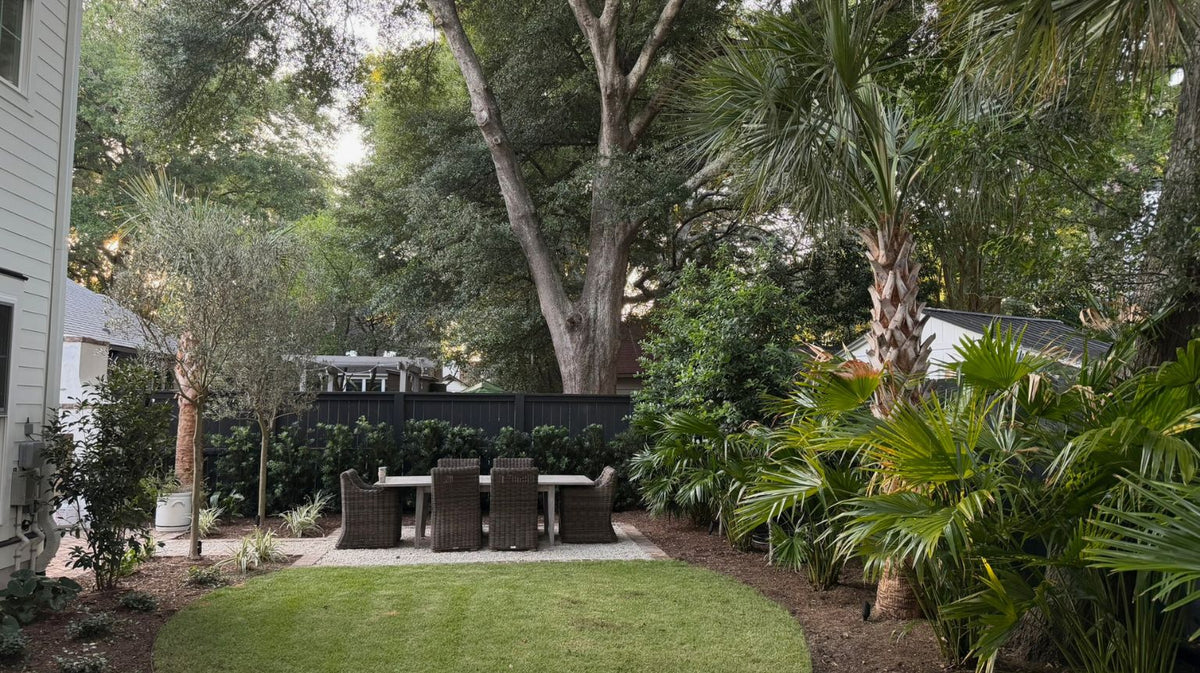 Small Charleston backyard with layered landscaping, garden pathways, privacy planting, and functional outdoor living spaces