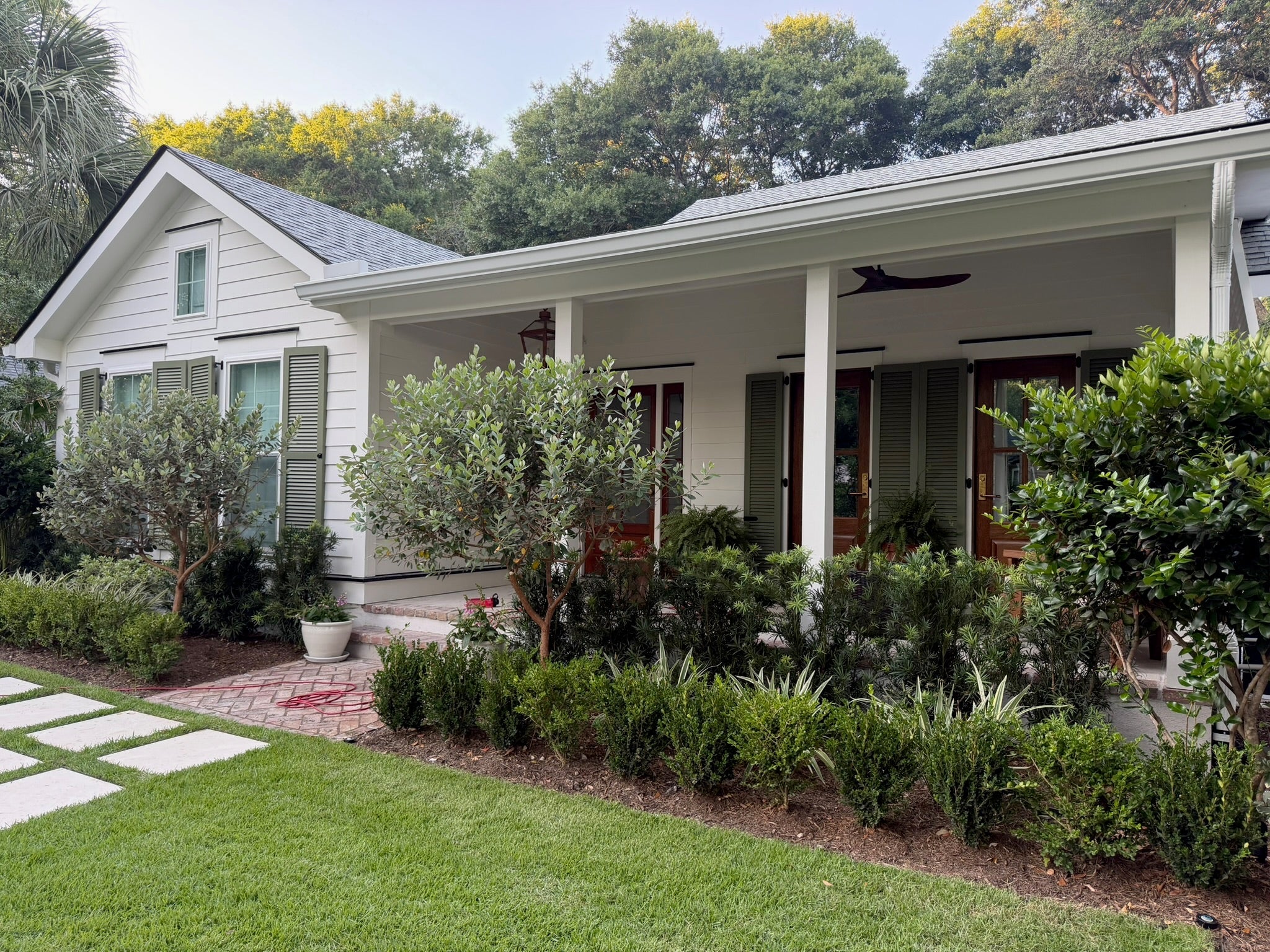 White Charleston home with Benjamin Moore Simply White exterior paint and Great Barrington Green shutters