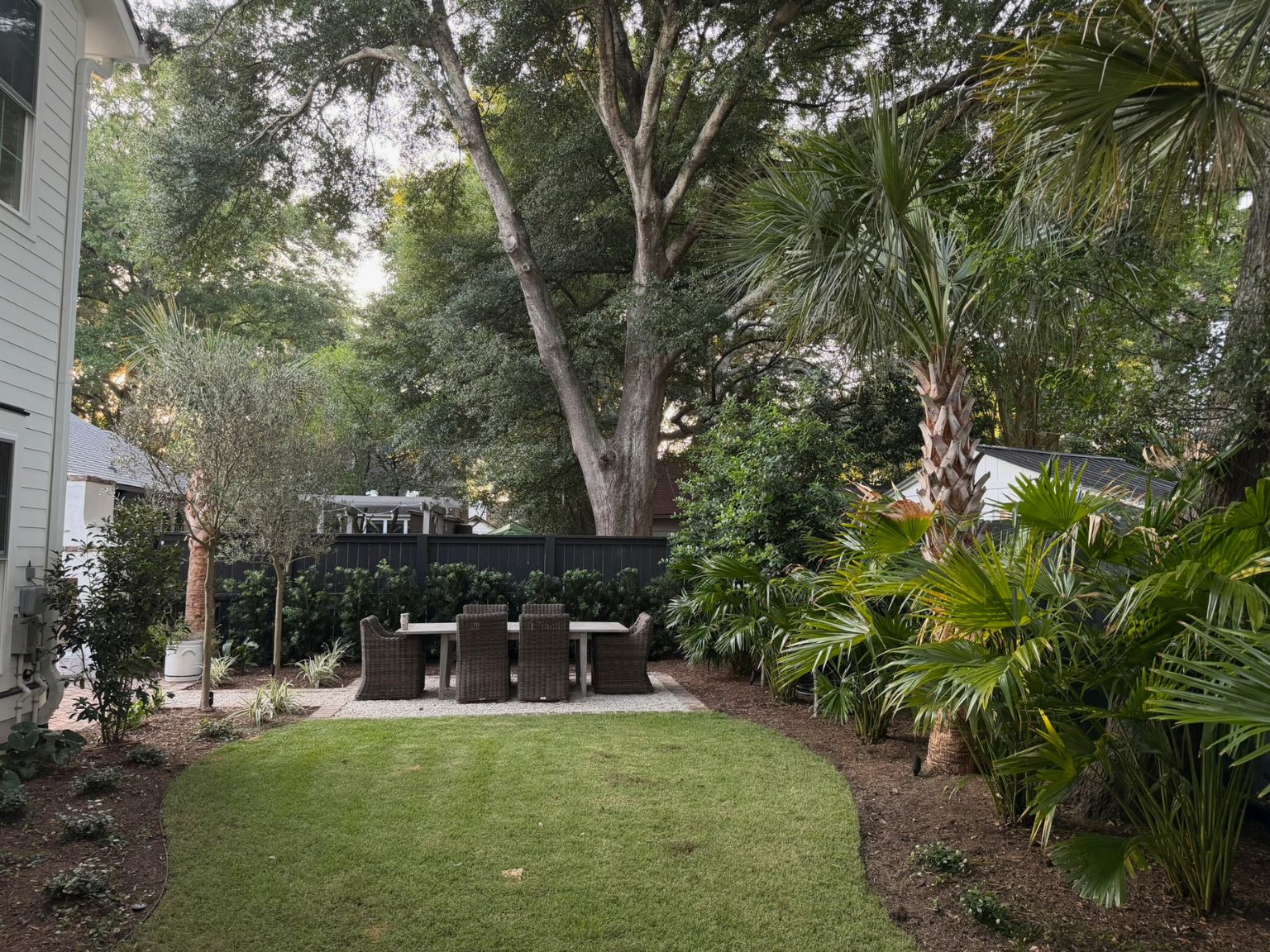 Small Charleston backyard with layered landscaping, garden pathways, privacy planting, and functional outdoor living spaces